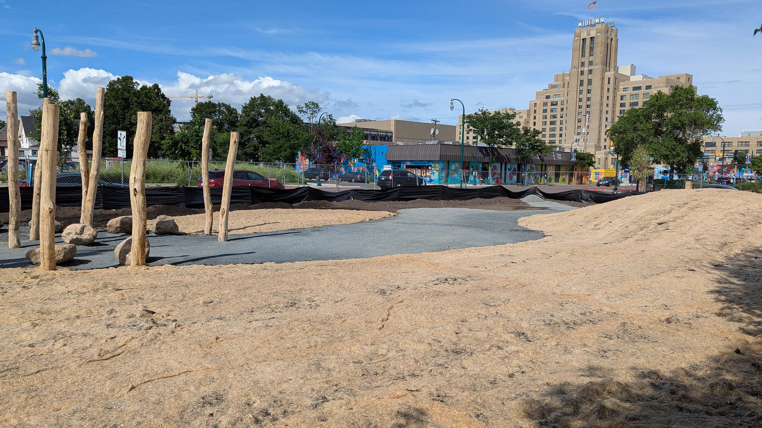 A park during construction on Lake Street in Minneapolis with the Midtown Building in the background.